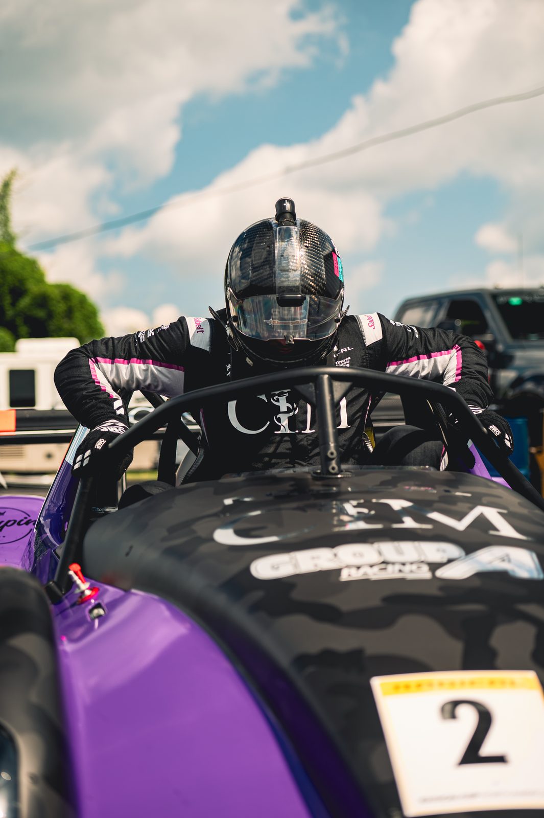 Driver climbing into a purple Radical cockpit