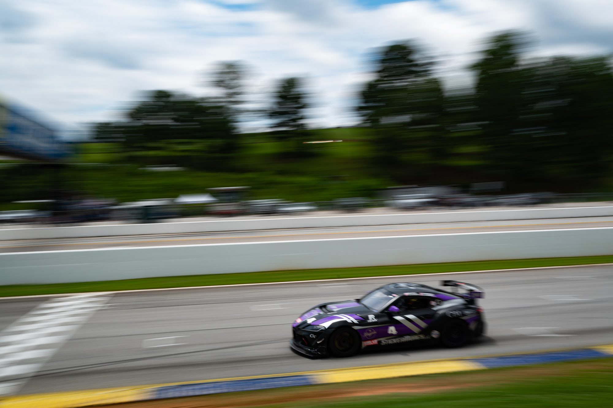 Toyota GR Supra GT4 at speed, blurred by a panning shot