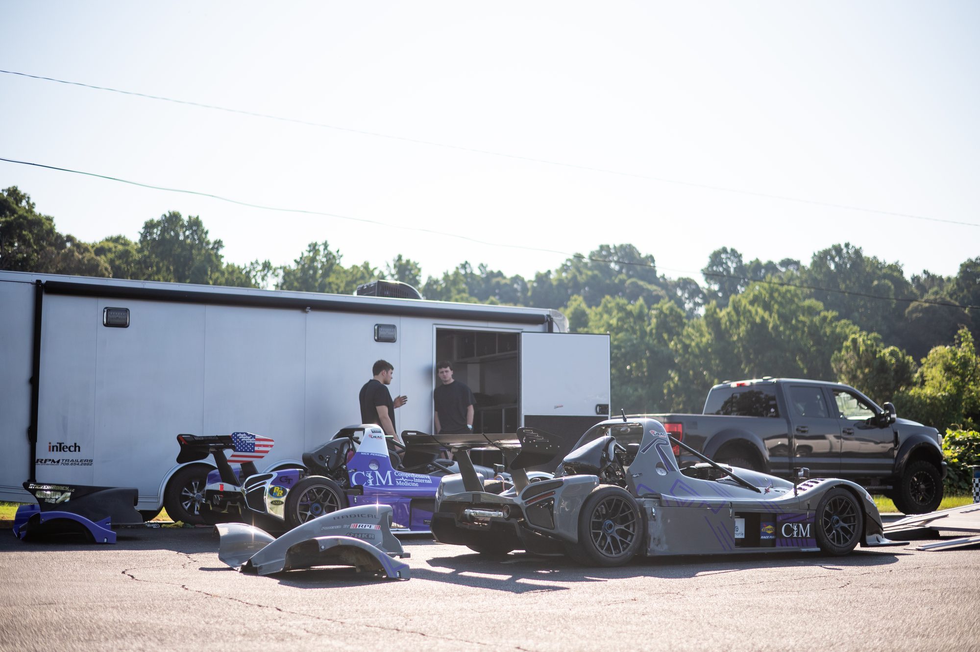 Two Radicals and a race trailer in the paddock
